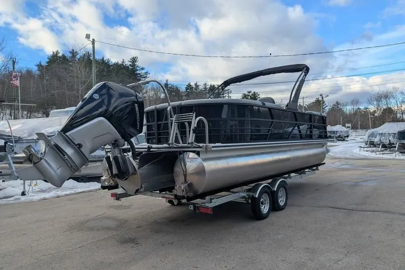Slide: The Image of 2026 Berkshire 24RFX CTS pontoon boat on trailer, parked outdoors under cloudy sky. - 2