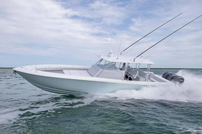 Slide: The Image of 2026 Contender 44 Fisharound boat displayed indoors with Mercury engine. - 1