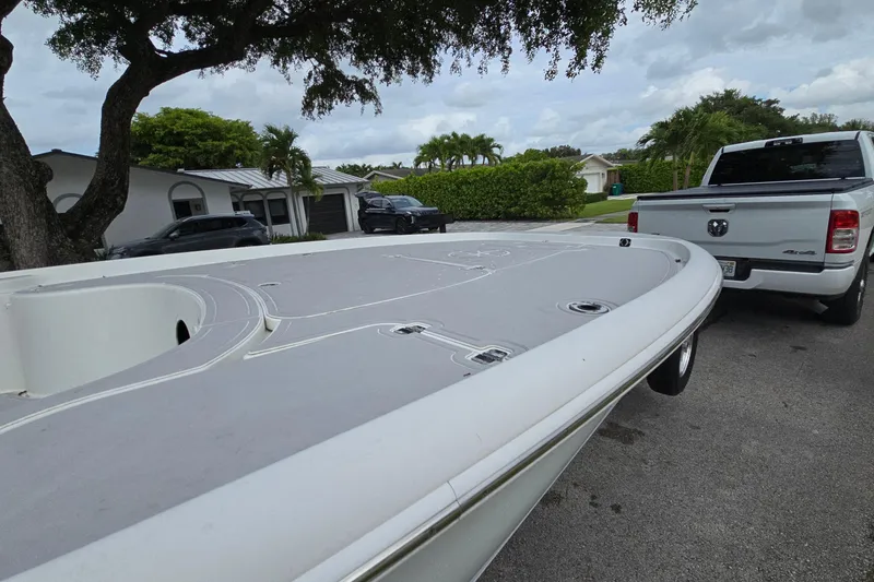 Slide: The Image of 2007 Yellowfin 24 Bay boat on trailer, parked near white pickup truck in suburban neighborhood. - 13
