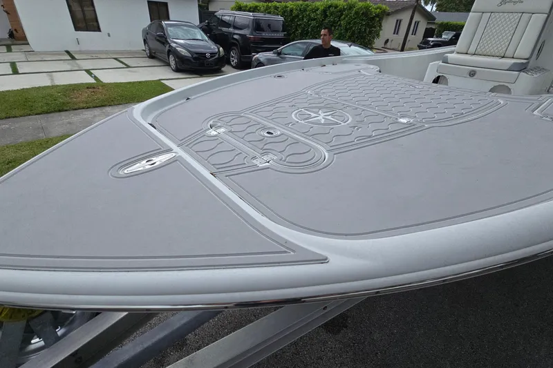 Slide: The Image of 2007 Yellowfin 24 Bay boat with custom deck design, parked in residential area. - 4