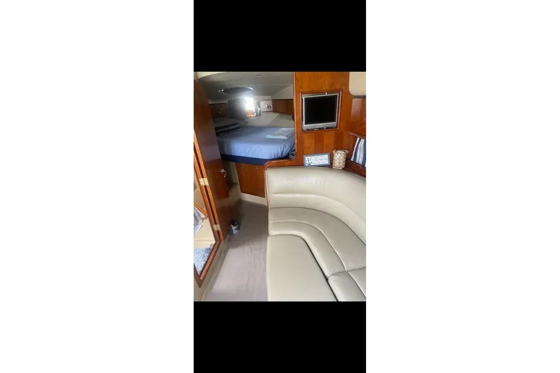 Slide: The Image of Interior of 2006 Cruisers Yachts 340 Express, featuring a cozy cabin and seating area. - 11
