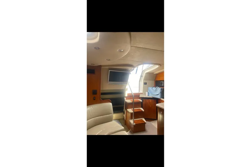 Slide: The Image of Interior of 2006 Cruisers Yachts 340 Express, featuring seating, stairs, and a television. - 15