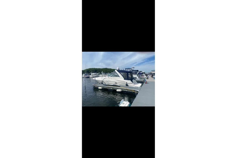 Slide: The Image of 2006 Cruisers Yachts 340 Express docked at a marina under a clear sky. - 2