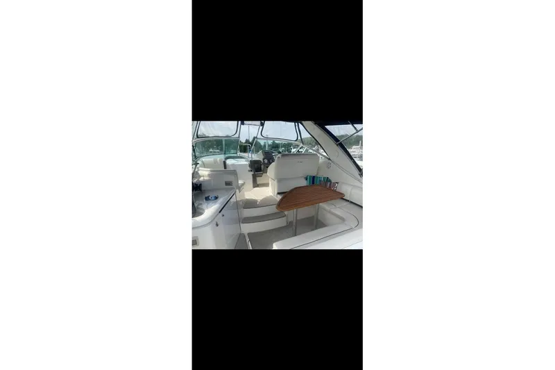 Slide: The Image of 2006 Cruisers Yachts 340 Express interior with seating and wooden table. - 5