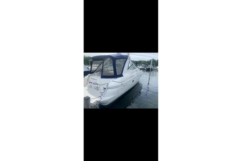 Slide: The Image of 2006 Cruisers Yachts 340 Express docked at marina, featuring blue canopy. - 6