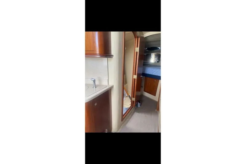 Slide: The Image of Interior of 2006 Cruisers Yachts 340 Express, featuring wood cabinetry and compact sink. - 12