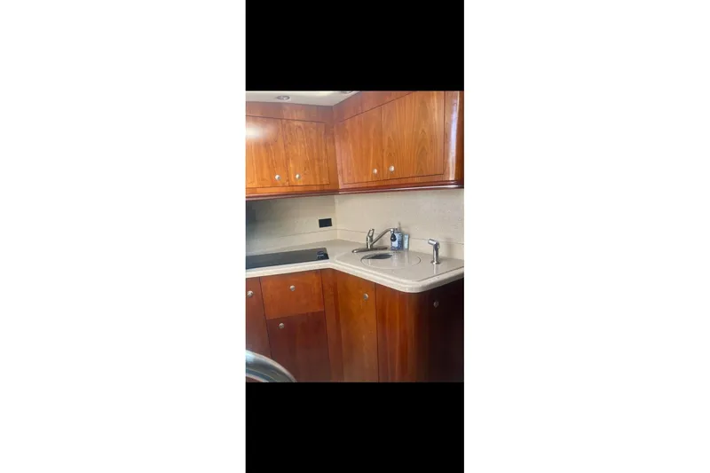 Slide: The Image of 2006 Cruisers Yachts 340 Express kitchen with wooden cabinets and sink. - 13