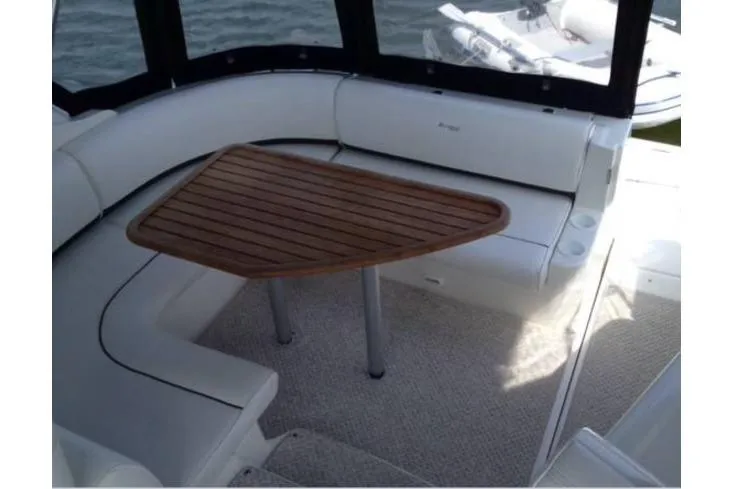 Slide: The Image of 2006 Cruisers Yachts 340 Express interior with wooden table and white seating. - 4