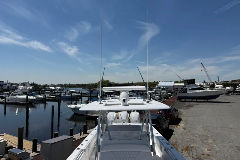 Slide: The Image of 2026 Contender 39 ST boat docked at a marina under a clear blue sky. - 12