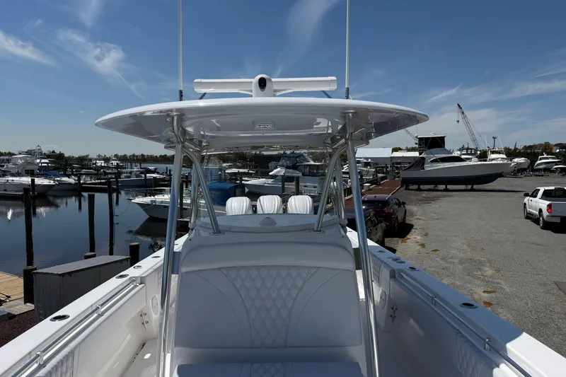 Slide: The Image of 2026 Contender 39 ST boat docked at marina, clear sky, multiple boats in background. - 13