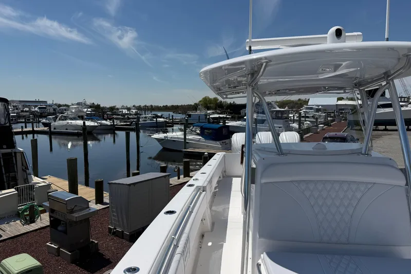 Slide: The Image of 2026 Contender 39 ST boat docked at a marina under a clear blue sky. - 17