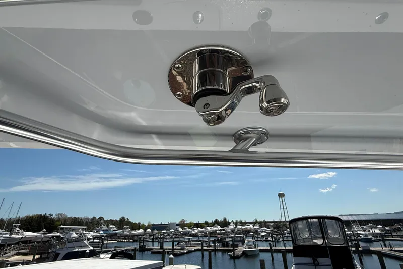 Slide: The Image of Chrome fixture on 2026 Contender 39 ST boat, overlooking marina with clear blue sky. - 22