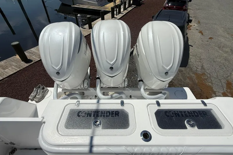 Slide: The Image of Triple outboard engines on a 2026 Contender 39 ST boat at a dock. - 27