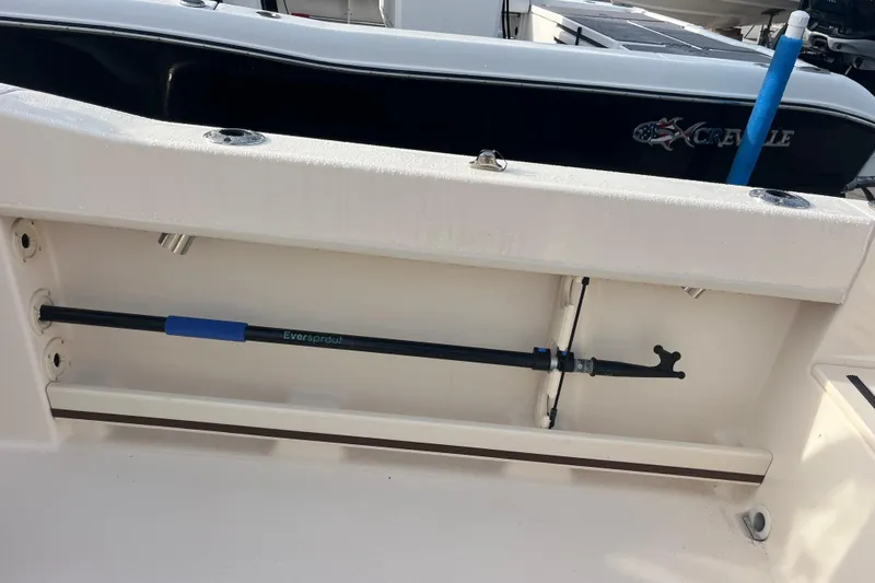 Slide: The Image of Storage compartment on a 2018 Grady-White Freedom 215 boat, featuring a secured Eversprout tool. - 11