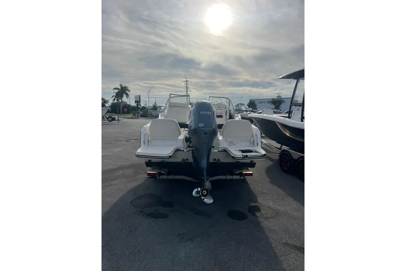 Slide: The Image of 2018 Grady-White Freedom 215 boat with outboard motor in a sunny parking lot. - 3