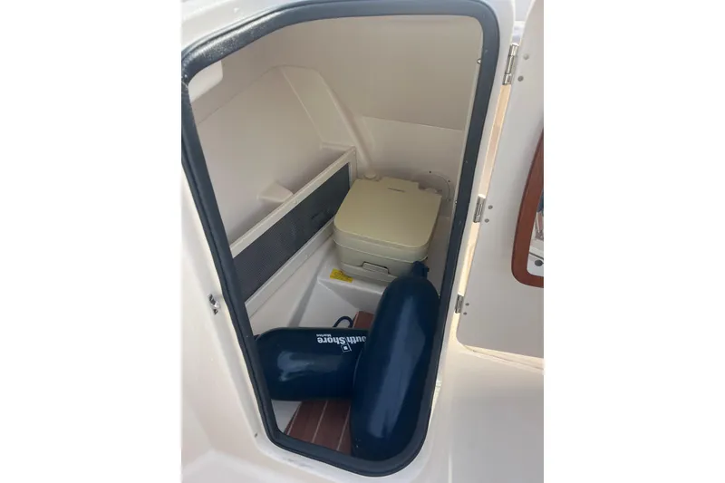 Slide: The Image of 2018 Grady-White Freedom 215 boat storage compartment with portable toilet and fender. - 7