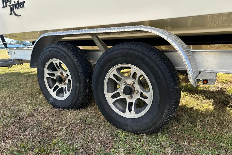 Slide: The Image of Trailer wheels of a 2020 Bay Rider 239 Bay boat on grass. - 12