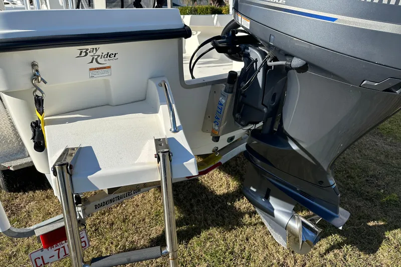 Slide: The Image of Bay Rider 239 Bay 2020 boat with outboard motor and ladder on grass. - 15