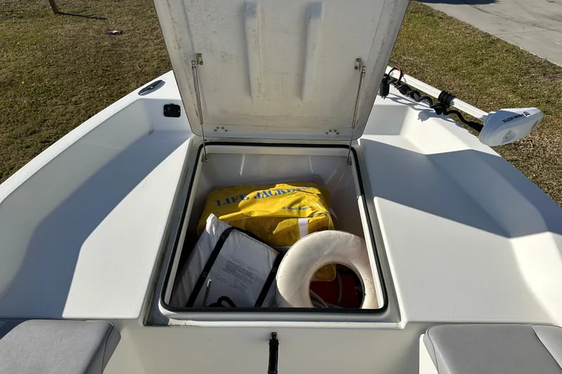 Slide: The Image of Open storage compartment on 2020 Bay Rider 239 Bay boat with life jackets and safety gear. - 19