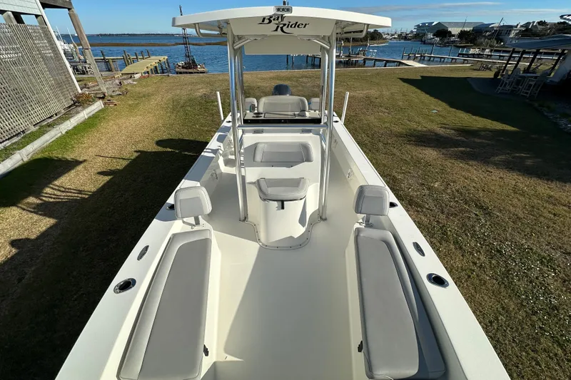 Slide: The Image of 2020 Bay Rider 239 Bay boat docked by the waterfront, showcasing spacious seating and sleek design. - 24