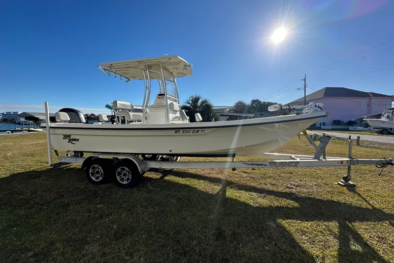 Slide: The Image of 2020 Bay Rider 239 Bay boat on trailer under bright sun. - 6
