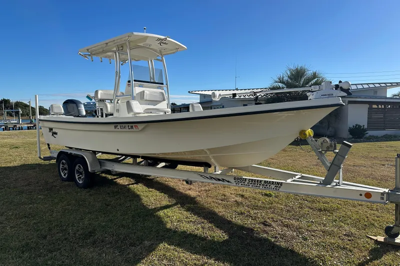 Slide: The Image of 2020 Bay Rider 239 Bay boat on trailer, parked on grass under clear blue sky. - 7