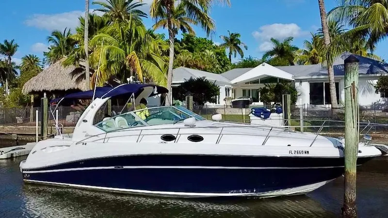 Slide: The Image of 2008 Sea Ray 420 Sundancer yacht docked near tropical waterfront homes. - 2