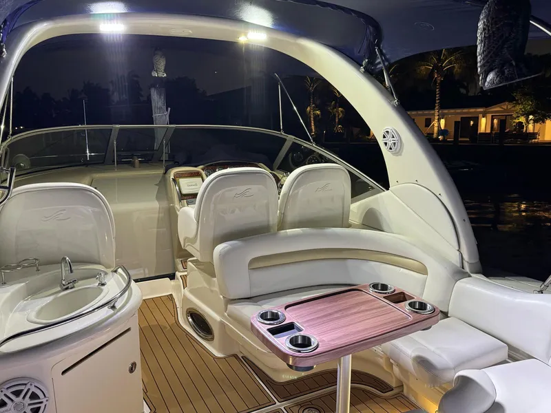 Slide: The Image of 2008 Sea Ray 340 Sundancer boat interior with seating and table, illuminated at night. - 45