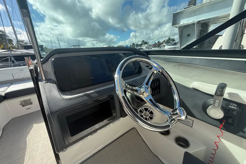 Slide: The Image of 2022 Regal LX6 boat cockpit with sleek steering wheel and modern controls. - 10