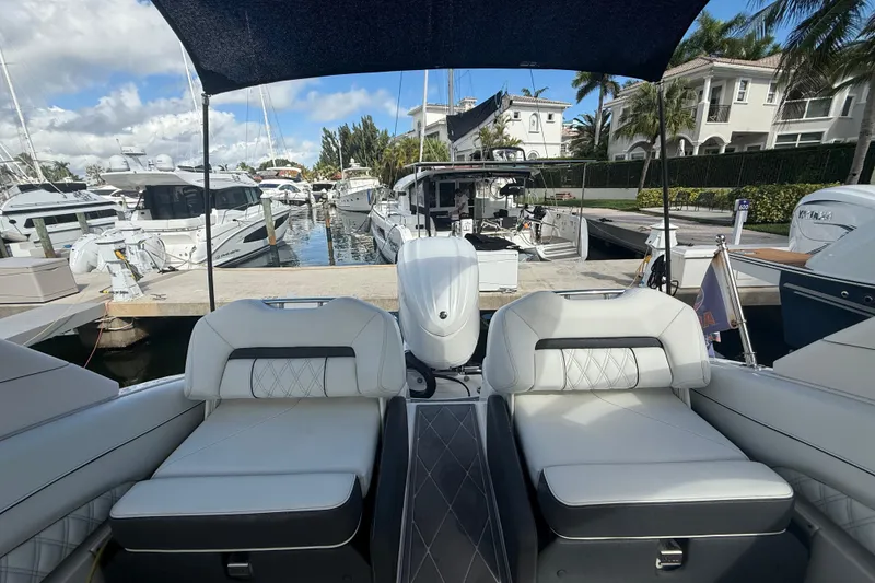 Slide: The Image of 2022 Regal LX6 boat interior with luxurious seating at a marina. - 12