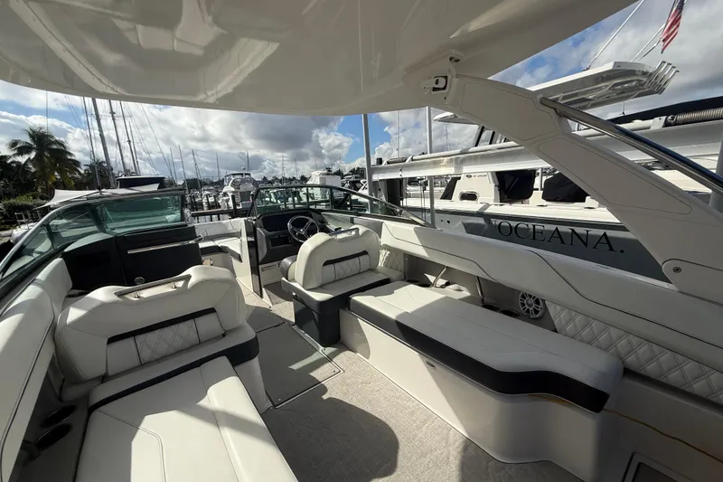 Slide: The Image of 2022 Regal LX6 boat interior with luxurious seating at a marina. - 2