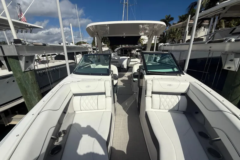 Slide: The Image of 2022 Regal LX6 boat interior with luxurious seating at a marina. - 23