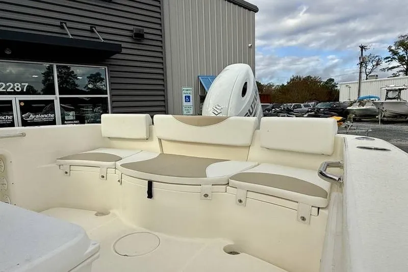 Slide: The Image of 2026 Bulls Bay 230 Center Console boat interior with cushioned seating, parked outside dealership. - 8