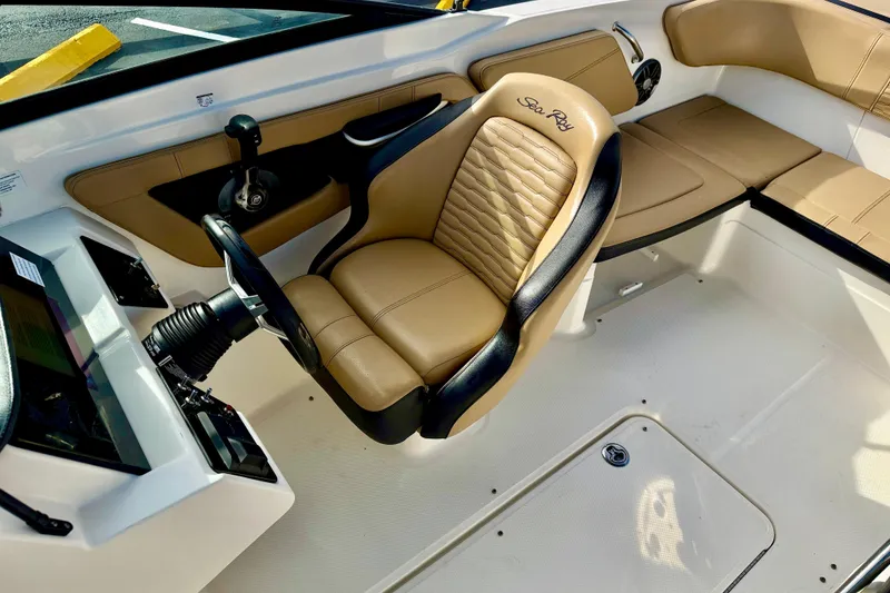 Slide: The Image of 2022 Sea Ray SPX 210 Outboard interior with tan leather seating and steering wheel. - 18