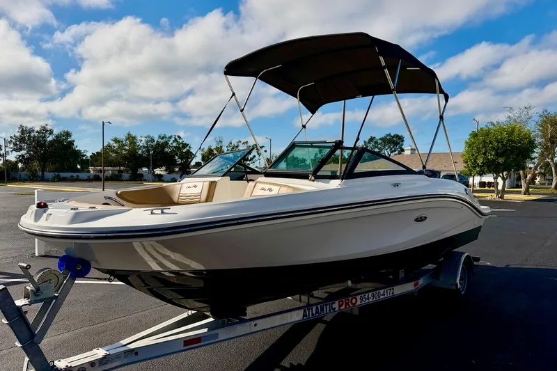 Slide: The Image of 2022 Sea Ray SPX 210 Outboard boat on trailer, parked outdoors under blue sky. - 2