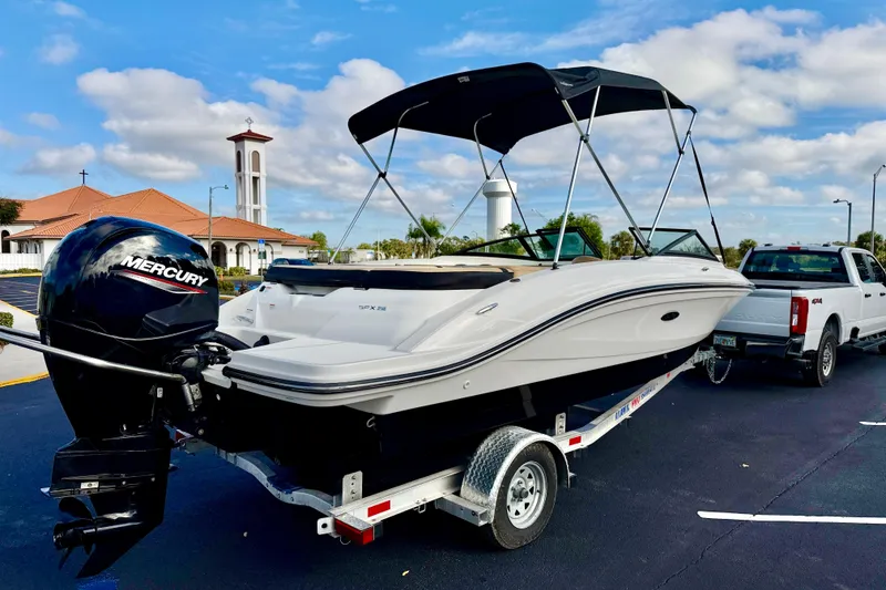 Slide: The Image of 2022 Sea Ray SPX 210 Outboard boat on trailer, parked near a church. - 4