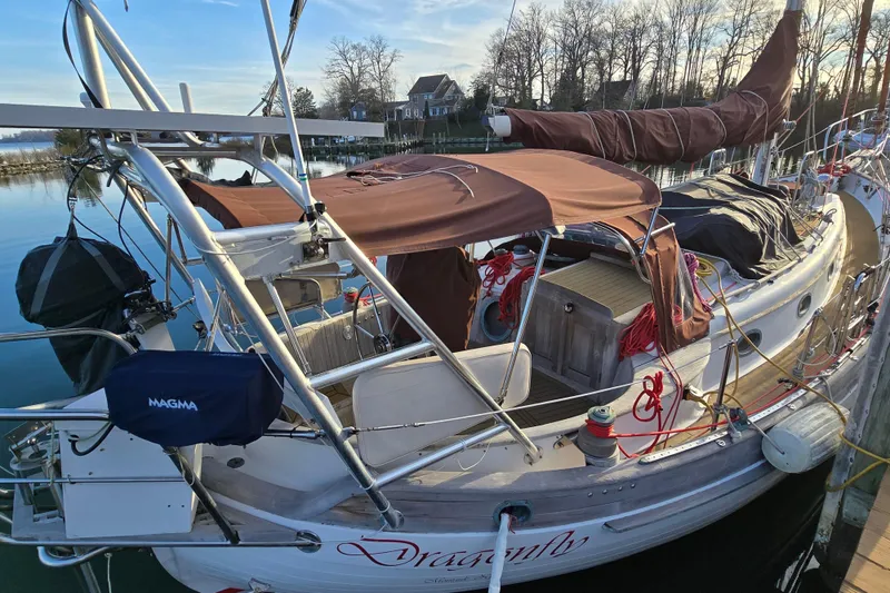 Slide: The Image of 1986 Hans Christian 38T sailboat docked, featuring brown covers and polished wood deck. - 10