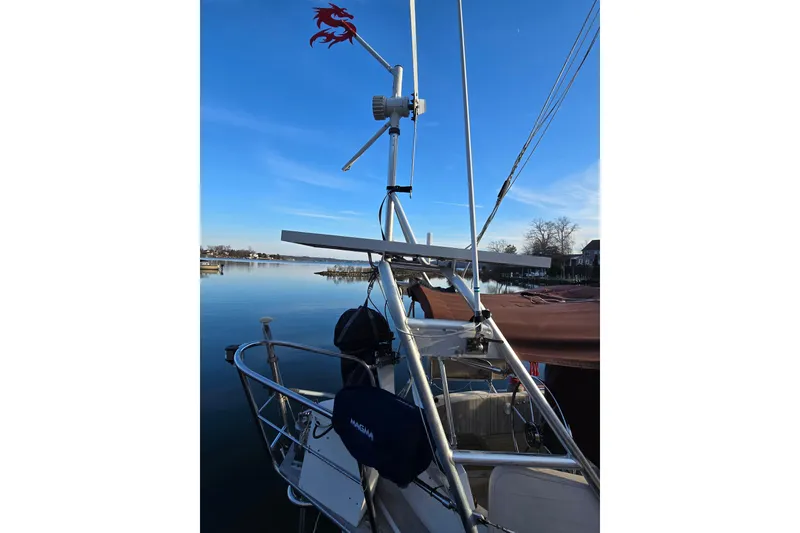Slide: The Image of 1986 Hans Christian 38T sailboat with wind turbine, docked on a calm lake. - 11