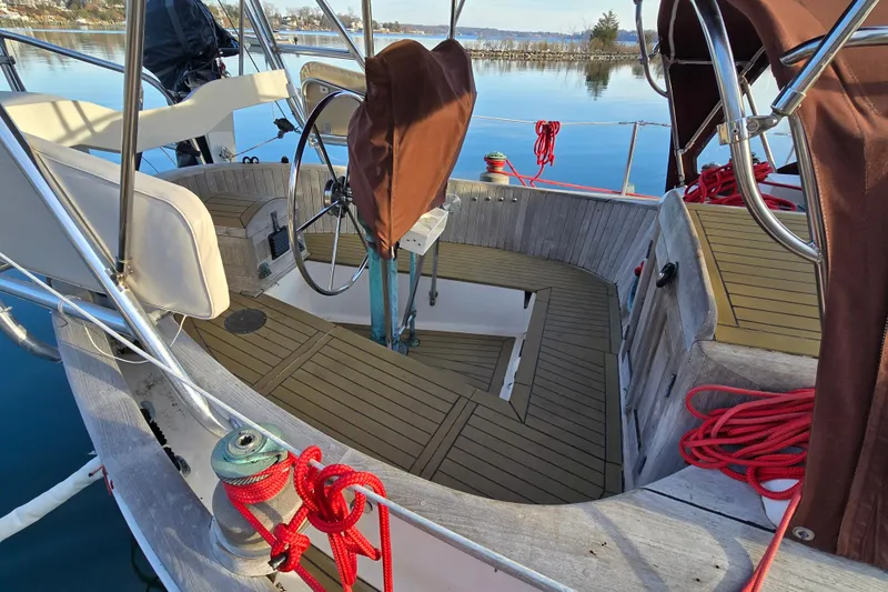 Slide: The Image of 1986 Hans Christian 38T sailboat cockpit with wooden deck and covered steering wheel. - 13