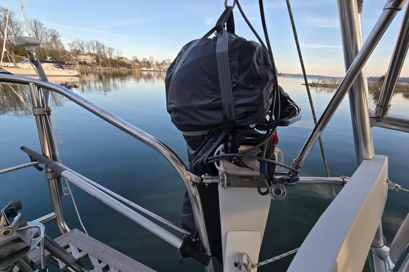 Slide: The Image of 1986 Hans Christian 38T sailboat with covered equipment, docked on calm water. - 17