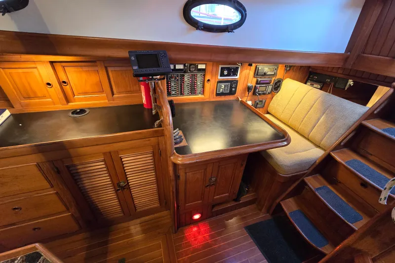 Slide: The Image of 1986 Hans Christian 38T yacht interior with navigation station, wooden cabinetry, and cushioned seating. - 25