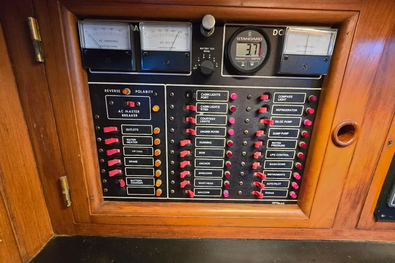 Slide: The Image of Electrical control panel on a 1986 Hans Christian 38T sailboat, featuring various switches and gauges. - 28