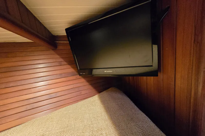 Slide: The Image of Flat-screen TV mounted in a 1986 Hans Christian 38T yacht's wooden interior cabin. - 34
