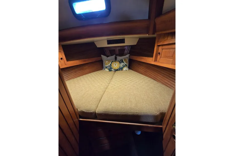 Slide: The Image of Cozy cabin interior of 1986 Hans Christian 38T sailboat with wooden finish and cushions. - 38