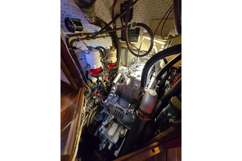 Slide: The Image of Engine room of 1986 Hans Christian 38T sailboat, showcasing mechanical components and wiring. - 48