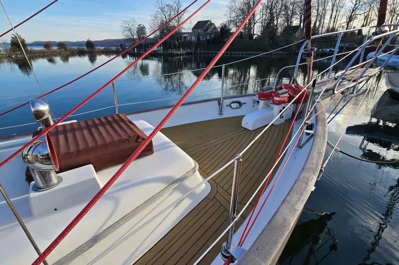 Slide: The Image of 1986 Hans Christian 38T sailboat deck with red ropes, docked by calm waters. - 6