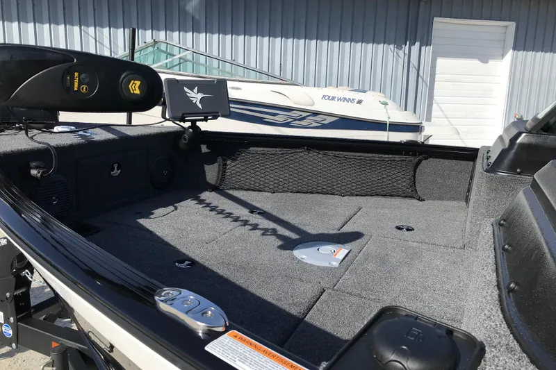 Slide: The Image of 2026 Lund 1775 Impact XS Sport boat interior with fishing equipment and storage compartments. - 14