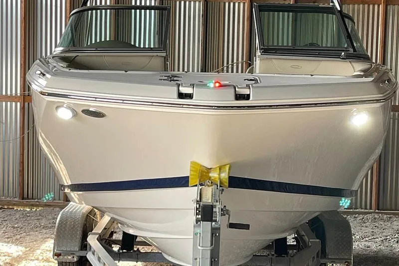 The Image of 2019 Regal 22 FasDeck boat on trailer, parked near a gray building. - 0