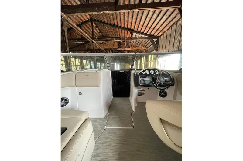 Slide: The Image of 2019 Regal 22 FasDeck boat interior with steering wheel and beige seating. - 34