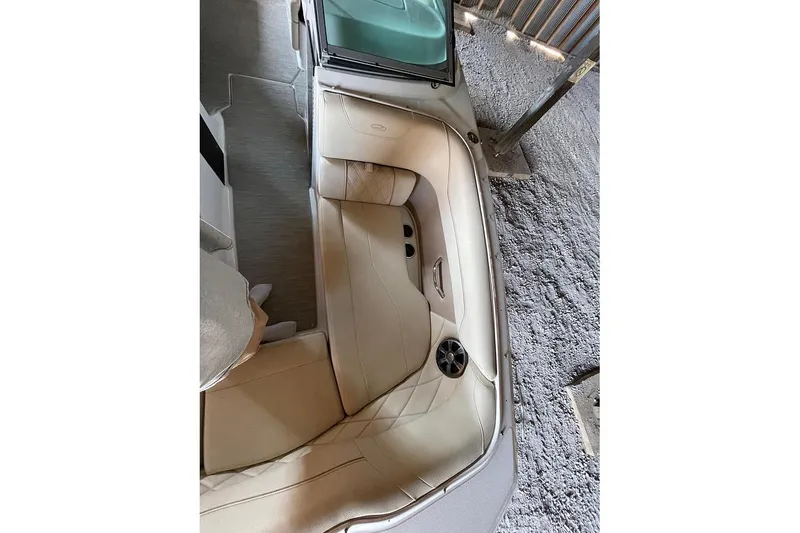 Slide: The Image of 2019 Regal 22 FasDeck interior storage compartment with cup holders and beige seating. - 38